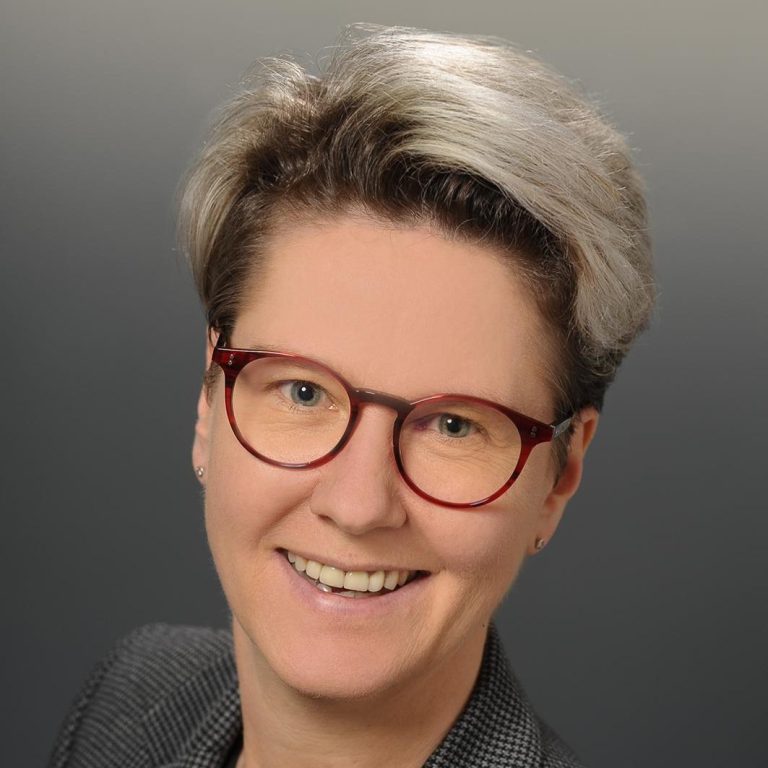 Freie Trauung mit Anke Hempfling Braut und Bräutigam während der Trauung im Freien, mit Rednerin Anke Hempfling im Hintergrund.